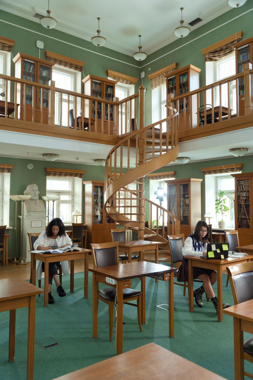 women sitting on chair inside a library